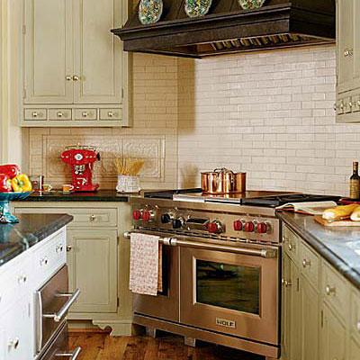 nehrđajući steel gas stove range in a kitchen with creamy, subway tiles as the backsplash behind the stove and light, tan kitchen cabinetry to the left and right of it