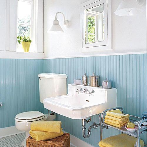 robin egg blue beaded board lines the bottom half of the remodeled bathroom with white walls above as well as a new white sink, white medicine cabinet and a toilet to the left