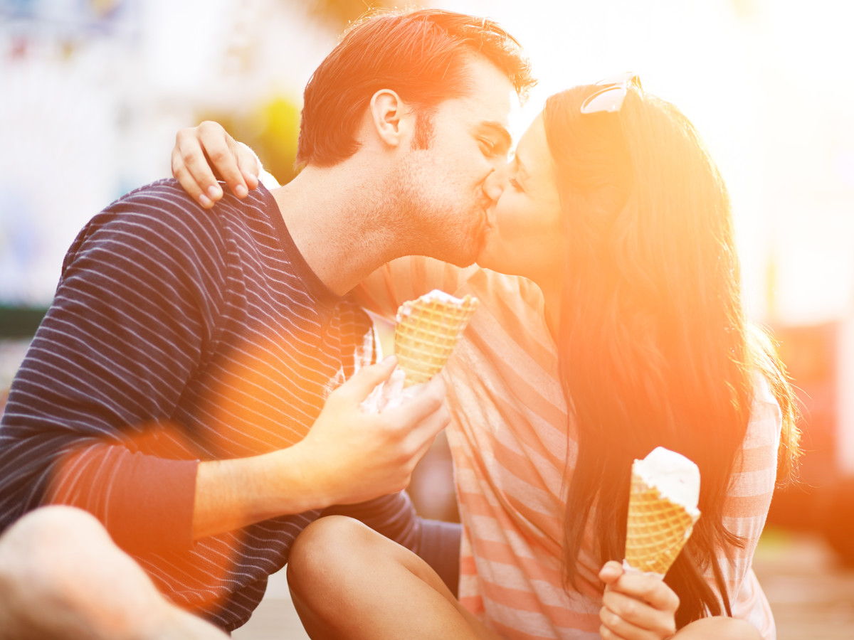 Ζευγάρι Kissing while Holding Ice Cream