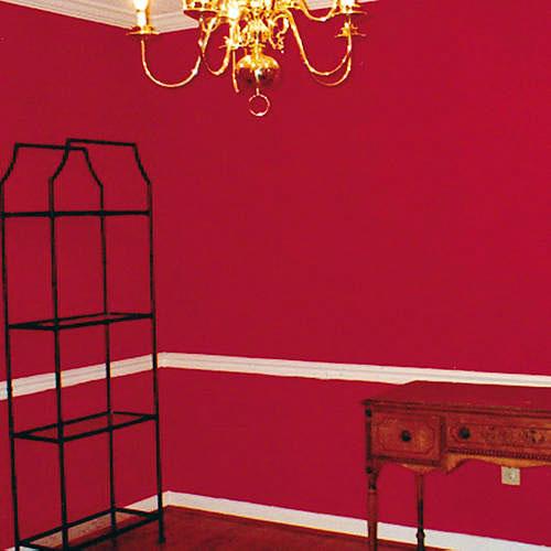 prije photo of a red painted dining room with spare furnishings 