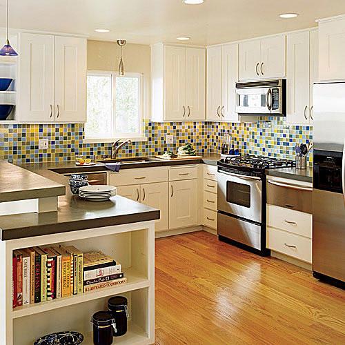 kirkas, blue, yellow, blue and brown tile splash gives the kitchen remodel a vivid design and makes the modern, white cabinets pop against the stainless steel refrigerator, stove and microwave 
