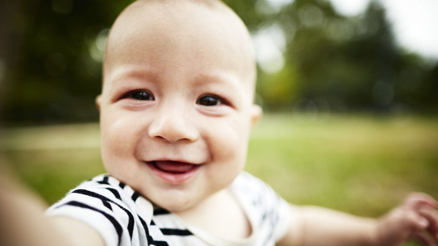 मुस्कराते हुए Baby Reaching for Camera