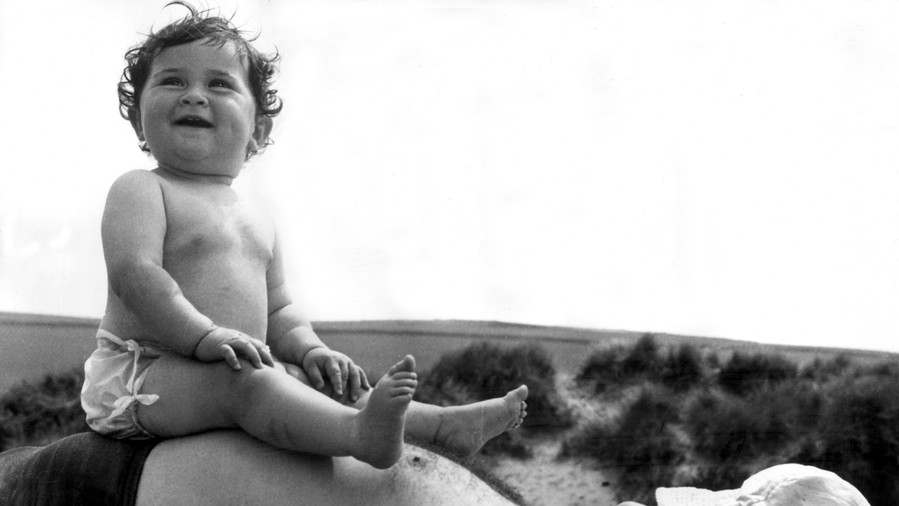 Bébé Sitting on Father at the Beach