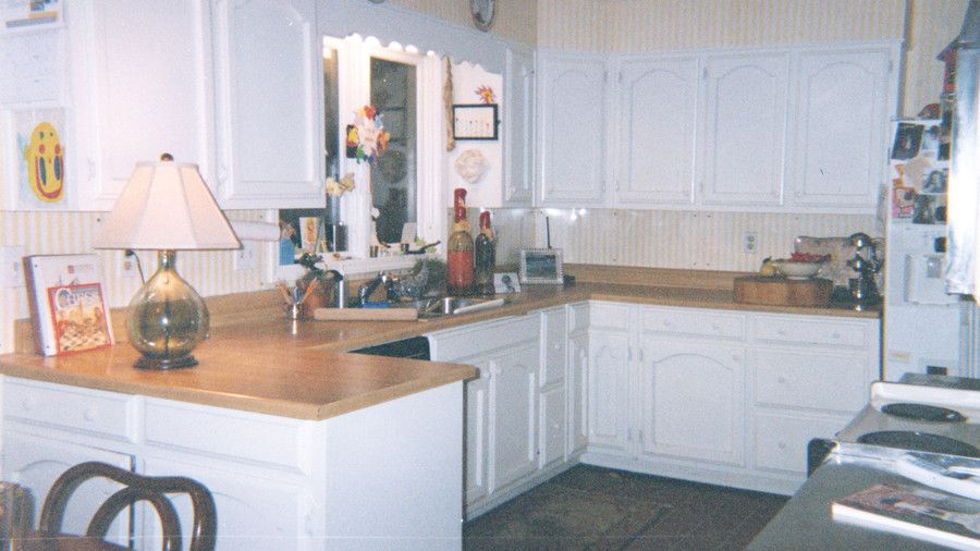 दिनांक kitchen with white cabinets, wooden countertops in a u-shape with a window over the sink