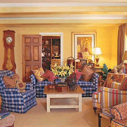 उज्ज्वल yellow walls liven up and compliment blue and white checkered couches and chairs in the living room 