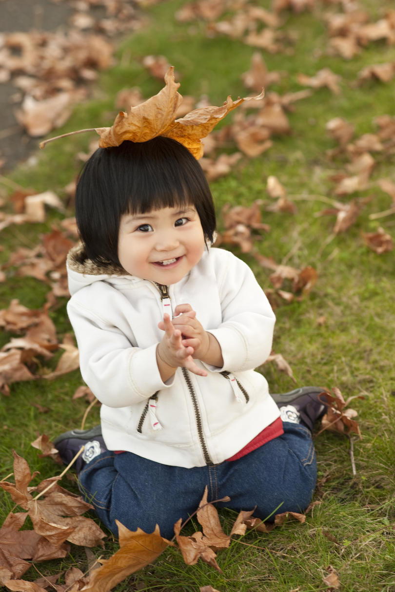 dijete koje je tek prohodalo playing in fall leaves