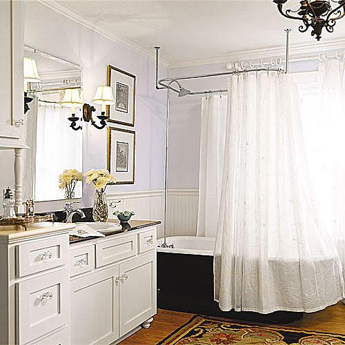 levegős white bathroom remodel with a black, clawfoot tub with a white shower curtain and a built-in custom sink cabinet with clear drawer knobs