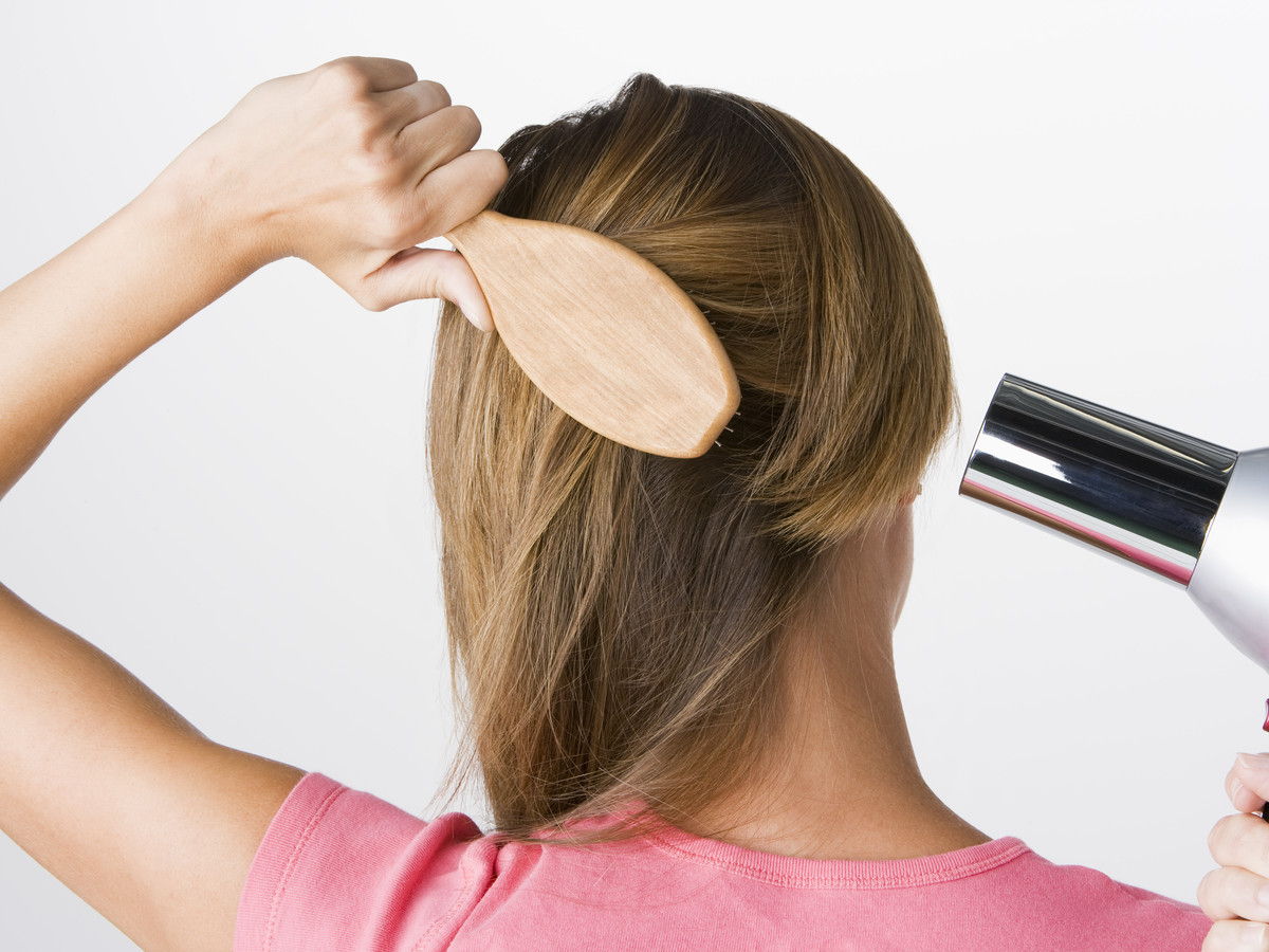 Femme brushing and drying hair